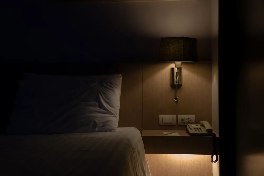 a bed with a phone and a telephone on a table